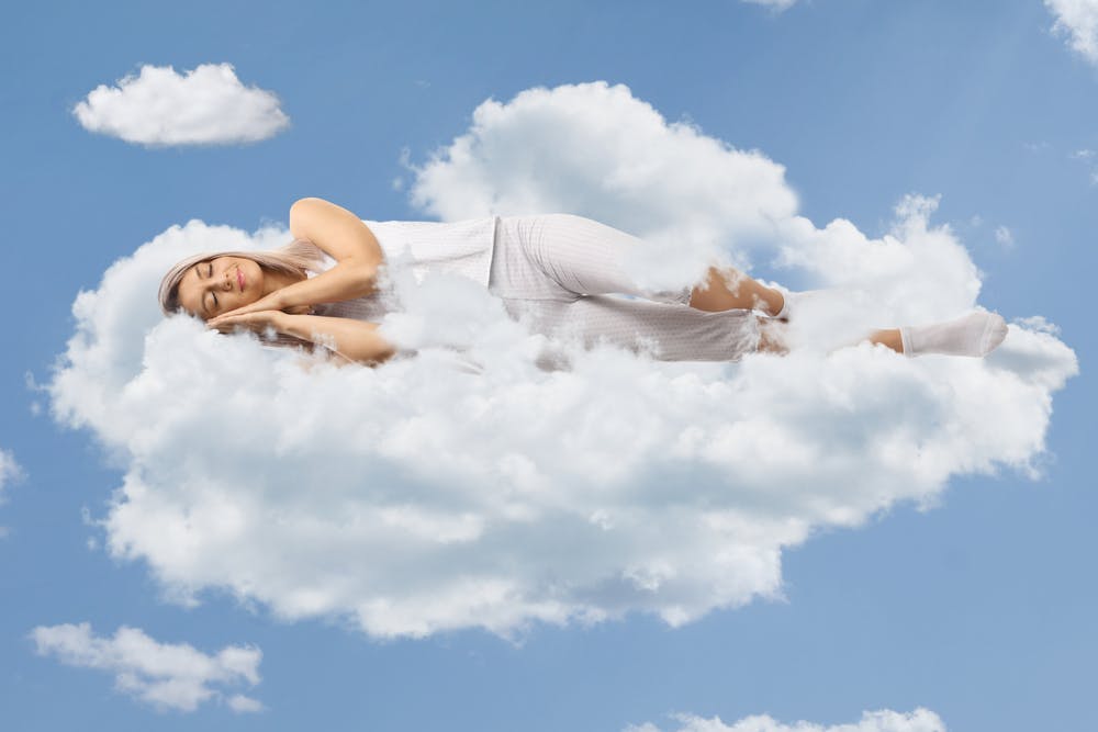 Frau schläft auf einer Wolke